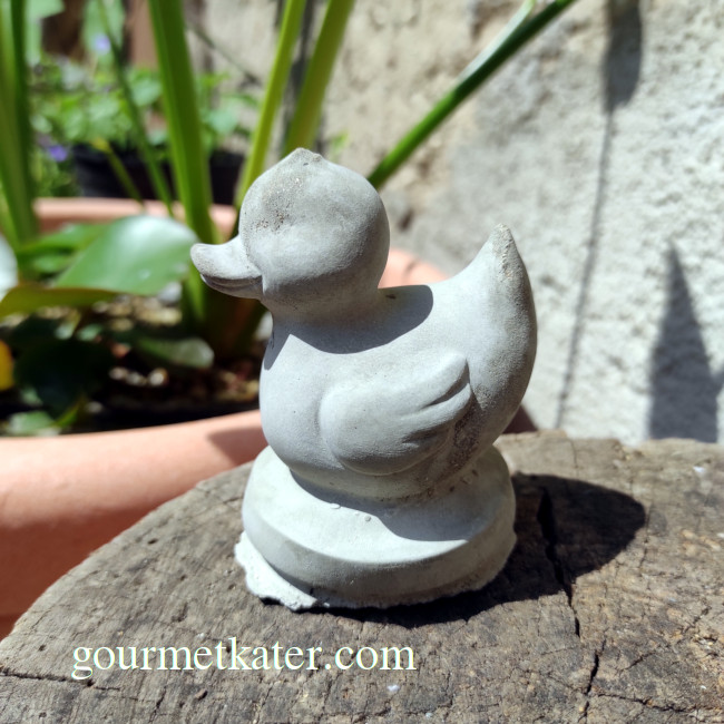 Kleine Ente aus Beton im Garten